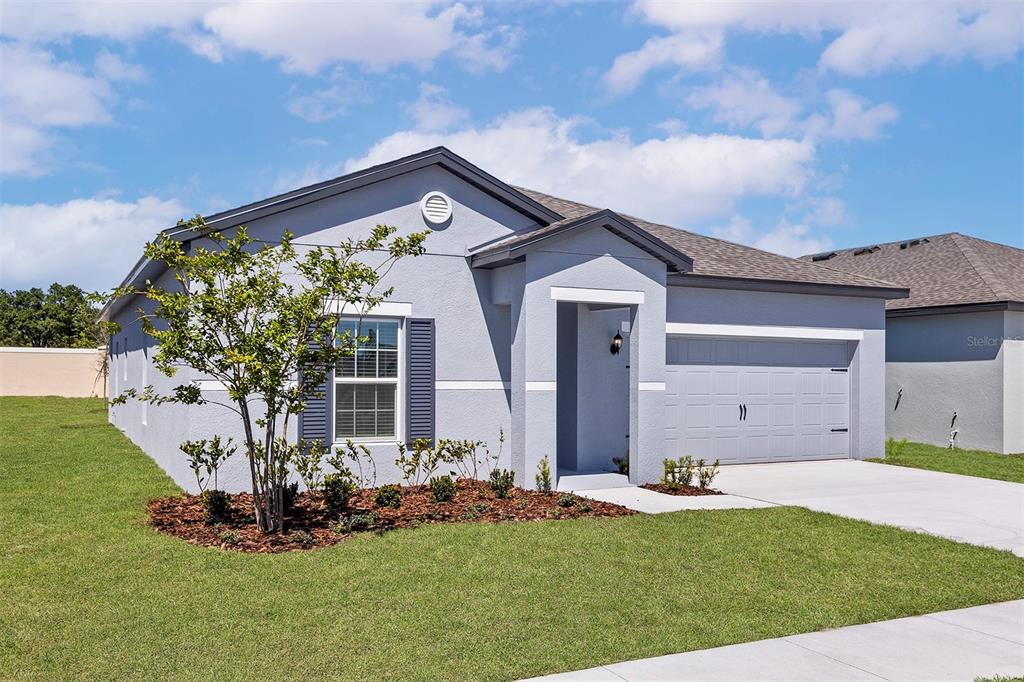 A single-story gray house with a two-car garage and a small front yard — 1787 WHITE ELEPHANT LOOP, WINTER HAVEN, FL