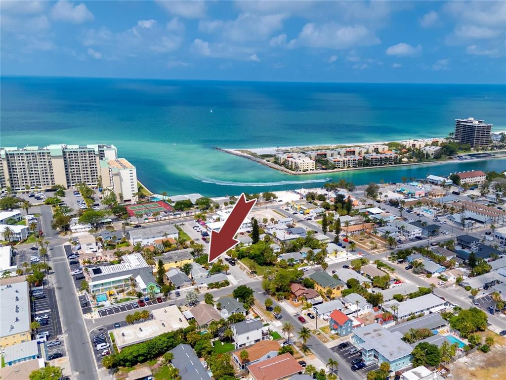 An aerial view shows a residential neighborhood near a beach and coastal waterway — 608 72ND AVENUE, ST PETE BEACH, FL