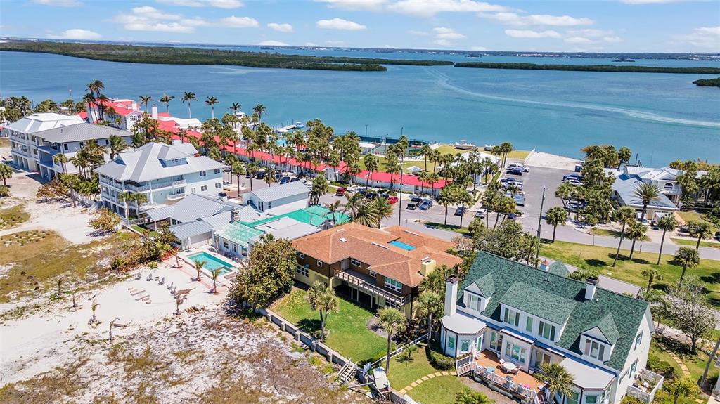 An aerial view shows several waterfront homes with pools and palm trees near the ocean — 1058 ELDORADO AVENUE, CLEARWATER BEACH, FL