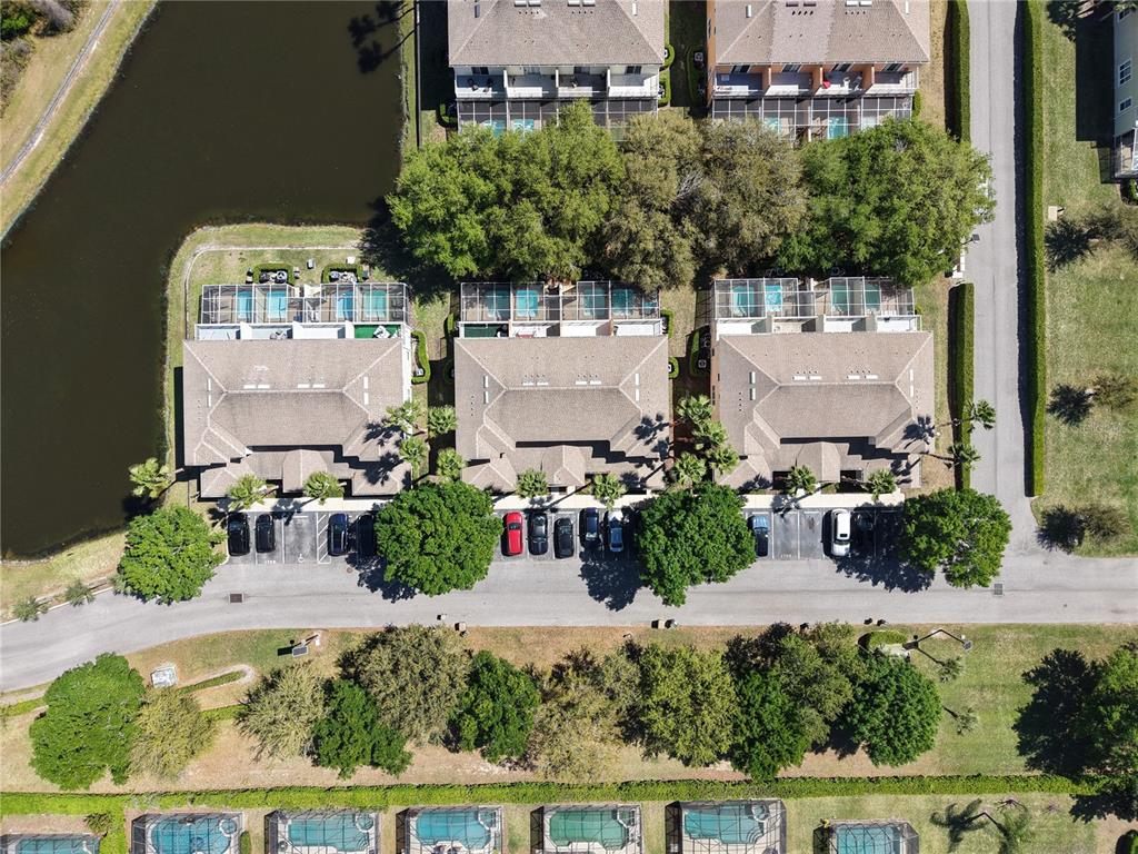 An aerial view shows several townhome buildings with screened-in pools and a parking lot — 1711 RETREAT CIRCLE, CLERMONT, FL