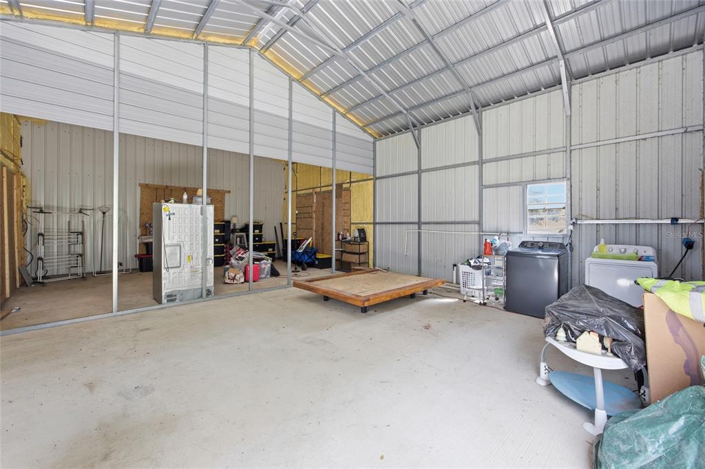 An unfinished metal-framed workshop or garage with concrete floors and exposed wall studs — 3660 W HWY 329, REDDICK, FL