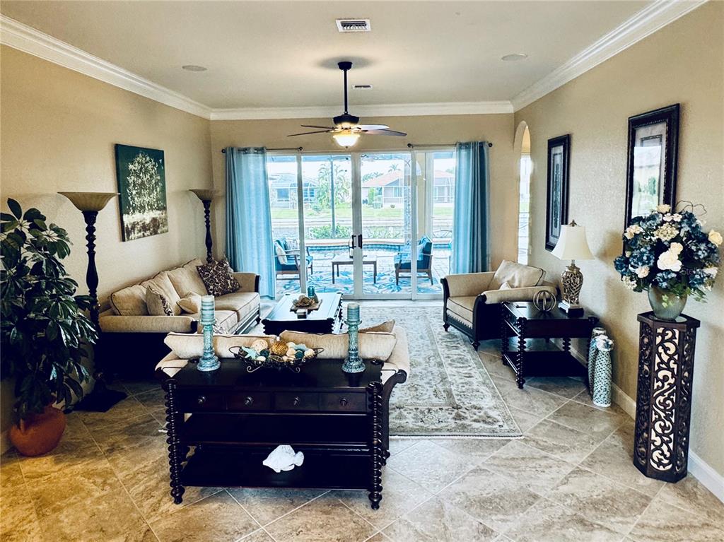 A living room features tile floors, a ceiling fan, and sliding glass doors to a patio — 1024 SAN MATEO DRIVE, PUNTA GORDA, FL