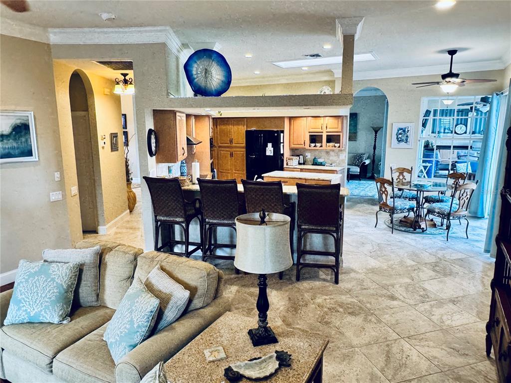A living room opens to a kitchen with a breakfast bar and dining area — 1024 SAN MATEO DRIVE, PUNTA GORDA, FL