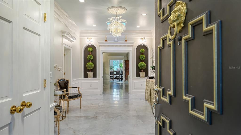 A grand foyer features marble floors, a crystal chandelier, and a dark door with gold trim — 75 OSPREY POINT DRIVE, OSPREY, FL