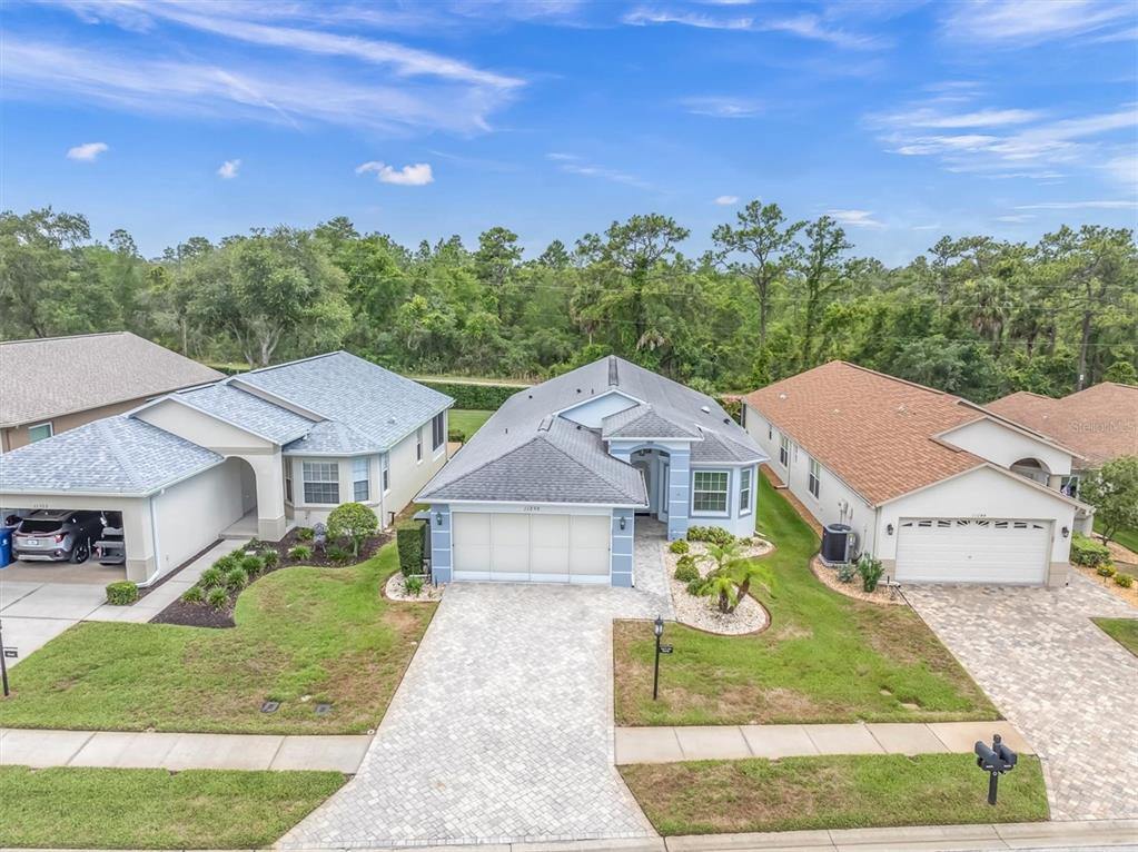 An aerial view shows a suburban house with a paved driveway and a two-car garage — 11250 HOLLANDER AVENUE, HUDSON, FL