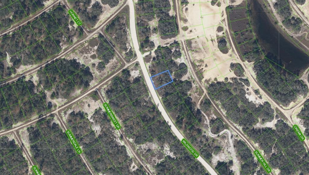 An aerial map view shows a highlighted vacant residential lot along a paved road — 323 WILDWOOD DRIVE, LAKE PLACID, FL