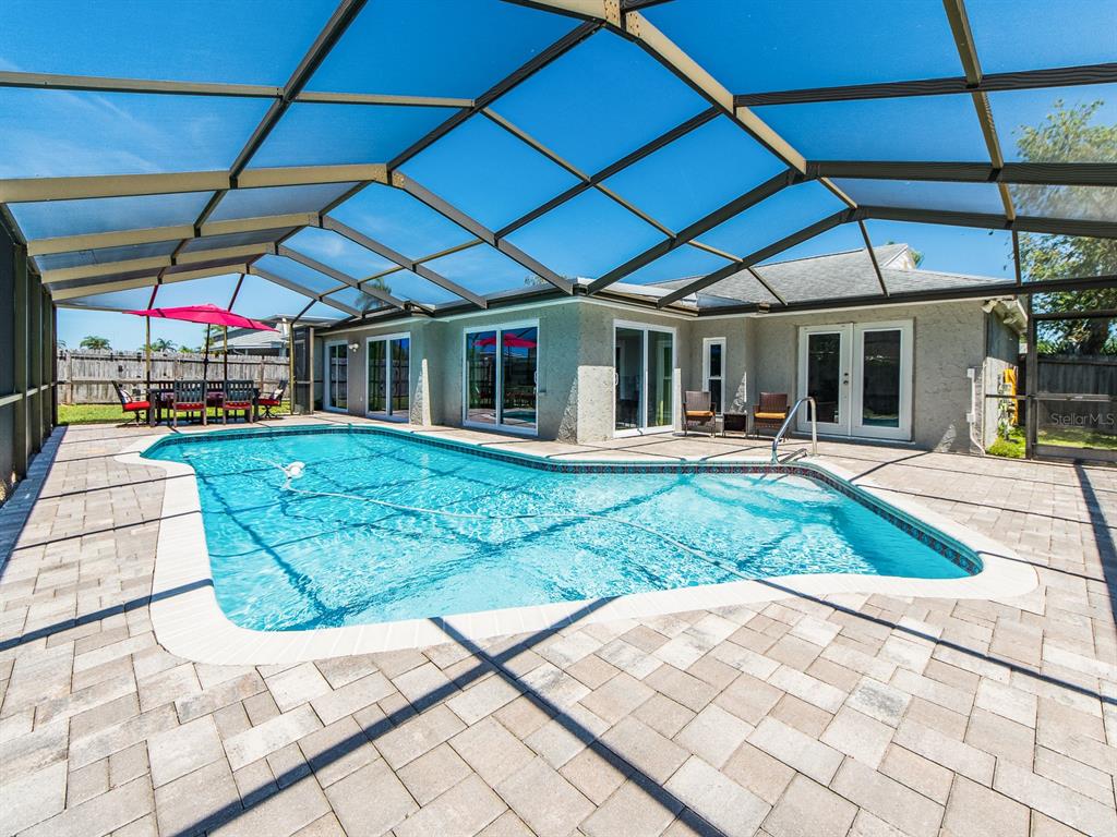 A screened-in patio features a swimming pool and a paved deck area — 3645 OVERLAND, HOLIDAY, FL
