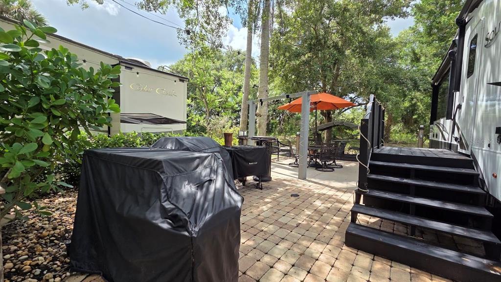 An outdoor patio area features a paved stone floor, a grill, and a dining set — 171 APPALOOSA TRAIL, RIVER RANCH, FL