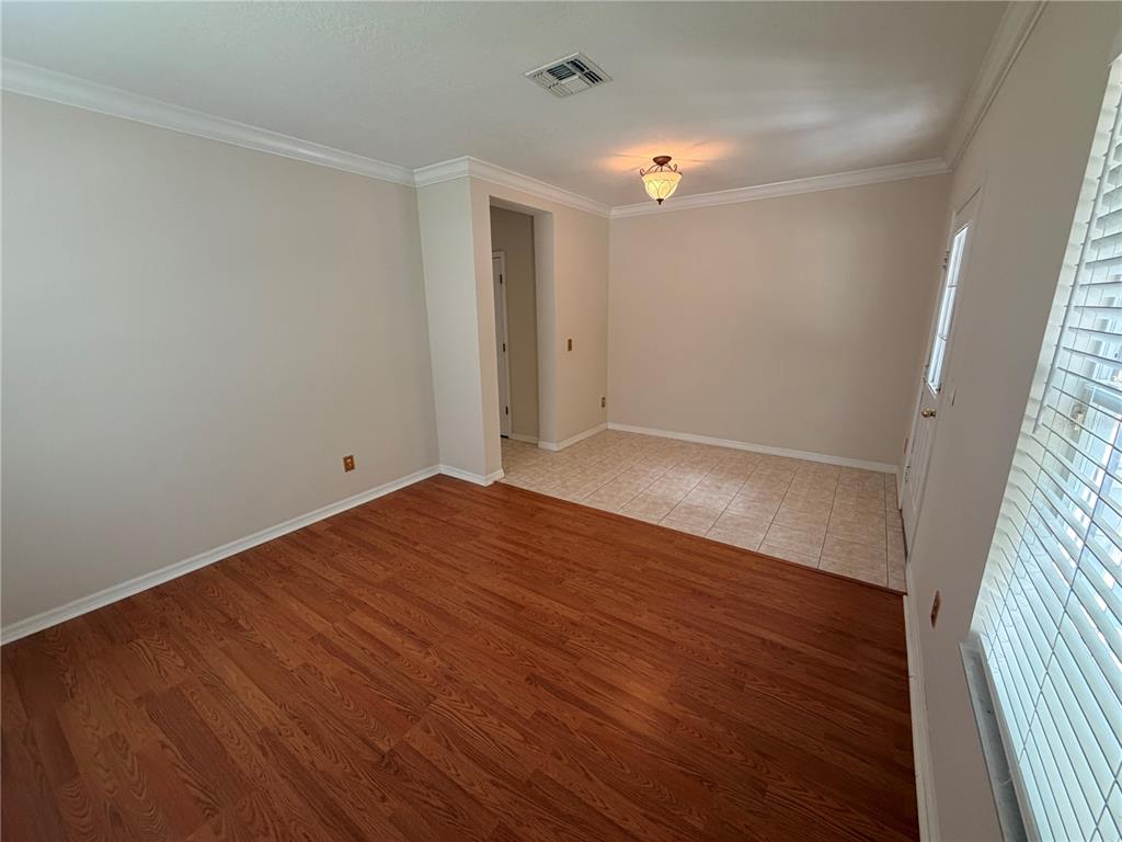 An interior room featuring wood-look flooring, a tiled area, a light fixture, and a doorway — 1003 OLD BLUSH ROAD, CELEBRATION, FL