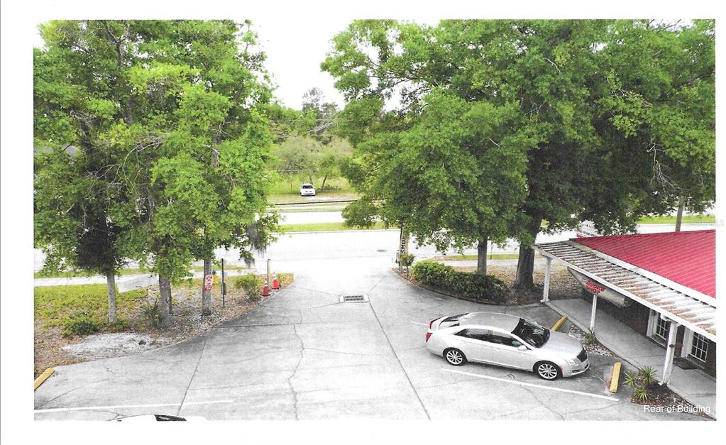 An elevated view shows a paved parking area behind a building with a red roof — 2820 HOWLAND BOULEVARD, DELTONA, FL