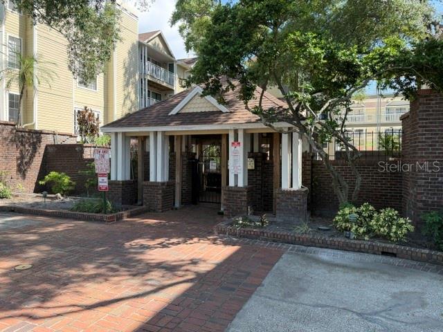 A brick-paved entrance leads to a covered walkway with brick columns and a gabled roof — 1000 W HORATIO STREET UNIT 226, TAMPA, FL