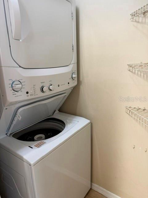 A white stacked washer and dryer unit sits in a small laundry closet with wire shelving — 1000 W HORATIO STREET UNIT 226, TAMPA, FL