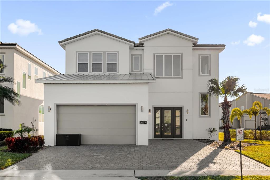A two-story white house with a two-car garage and a paved driveway — 2137 PINE OAK LOOP, DAVENPORT, FL