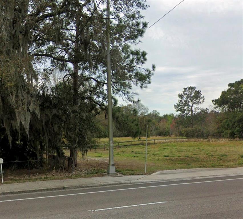 An aerial view shows a large, wooded plot of land outlined in red near a highway — 330 MARCUM ROAD, LAKELAND, FL