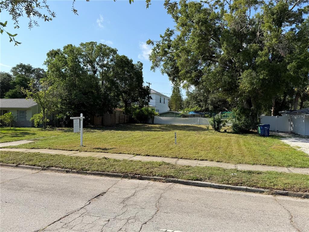 A vacant, grassy residential lot sits between two houses on a paved street — 4608 W EL PRADO BOULEVARD, TAMPA, FL