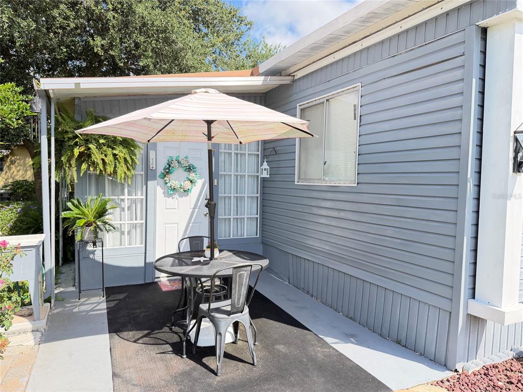 A patio area features a small round table, two chairs, and an umbrella outside — 5578 DENISE AVE, ORLANDO, FL