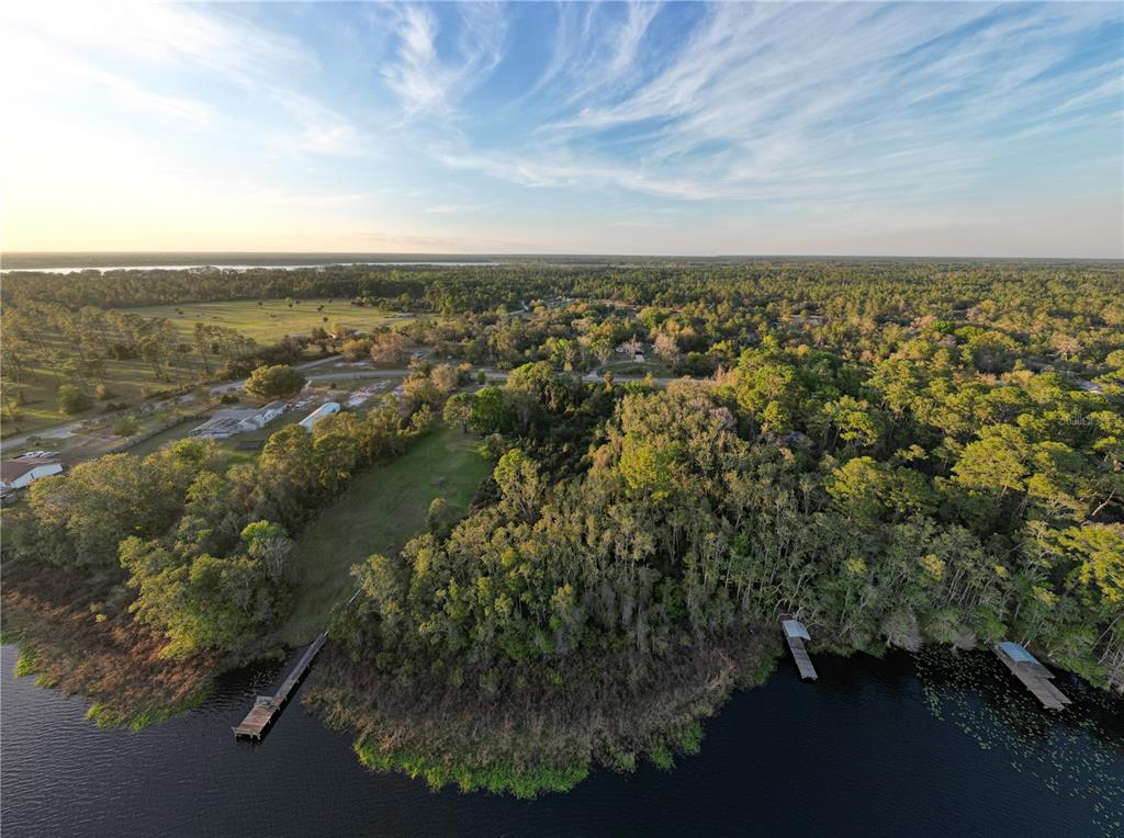 An aerial view of a grassy lot with a dock extending into a lake — #8 MITCHEL WAY, EUSTIS, FL