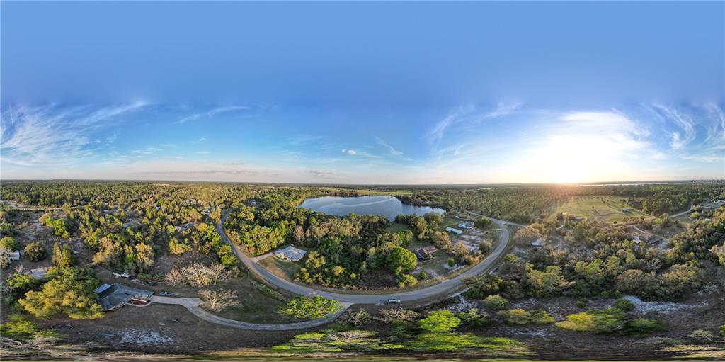 An aerial 360-degree panoramic view of a rural landscape featuring a lake and scattered houses — #8 MITCHEL WAY, EUSTIS, FL
