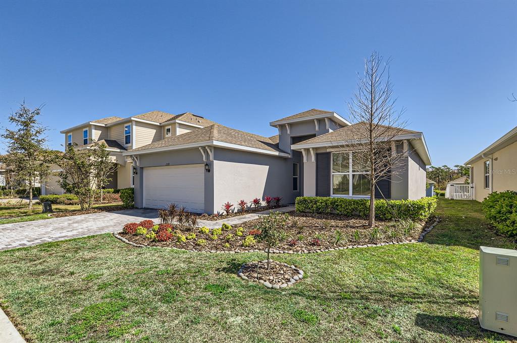 A single-story house with a two-car garage and a landscaped front yard — 2372 SIRENA LANE, MOUNT DORA, FL