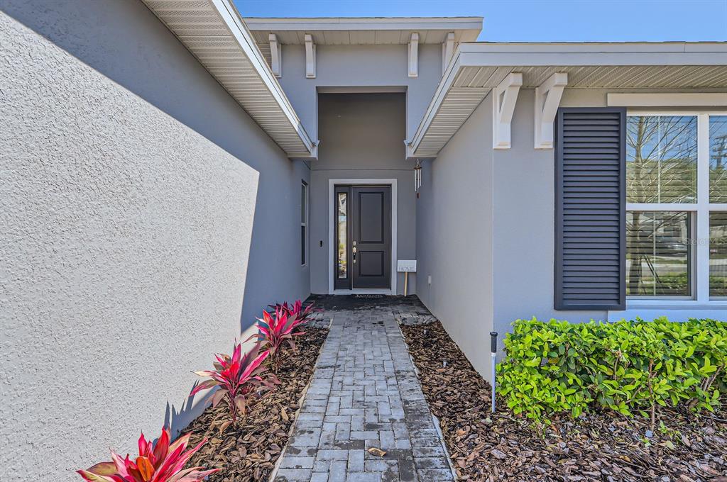A single-story house with a gray exterior, a two-car garage, and a landscaped front yard — 2372 SIRENA LANE, MOUNT DORA, FL
