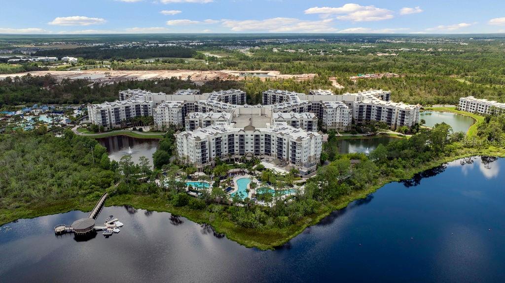 An aerial view of a large multi-story apartment complex surrounded by lakes and wooded areas — 14501 GROVE RESORT AVENUE UNIT 2542, WINTER GARDEN, FL