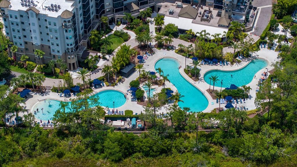 An aerial view shows a large apartment complex with multiple swimming pools and lush landscaping — 14501 GROVE RESORT AVENUE UNIT 2542, WINTER GARDEN, FL