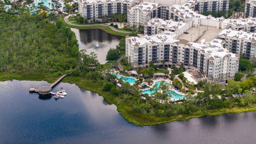 An aerial view of a large apartment complex with a swimming pool and a lake — 14501 GROVE RESORT AVENUE UNIT 2542, WINTER GARDEN, FL
