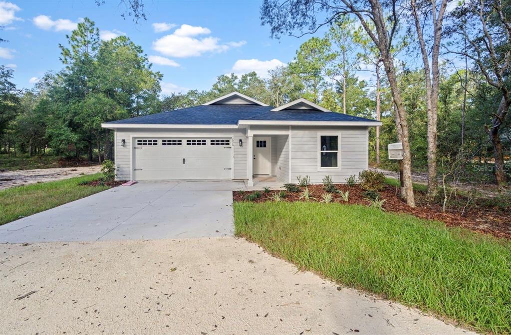 A single-story house under construction with a roof and exterior sheathing in a wooded lot — 7970 NE 102ND COURT, BRONSON, FL