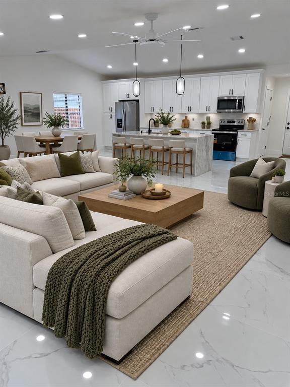 A bright, open-concept kitchen and living area features white cabinetry, marble-look tile flooring, and recessed lighting — 5308 BLACK PINE DRIVE, TAMPA, FL