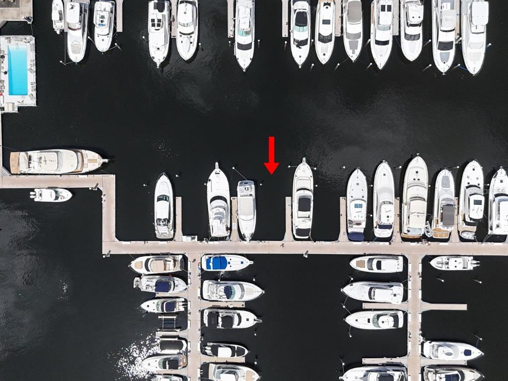 An aerial view shows a marina with numerous boats docked in slips along wooden piers — 102 RIVIERA DUNES WAY UNIT S-7, PALMETTO, FL