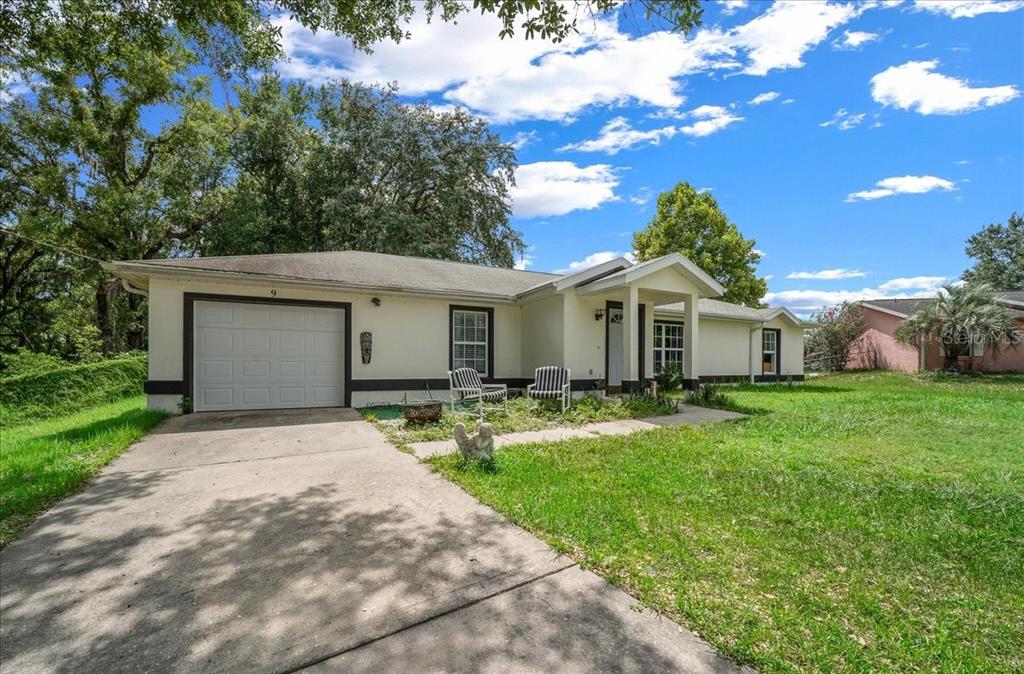 A single-story house with a white exterior, a one-car garage, and a concrete driveway — 9 PINE CIRCLE RUN, OCALA, FL