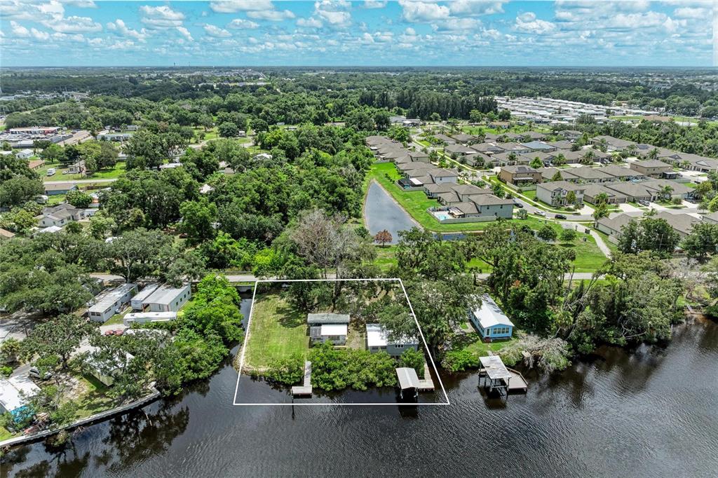 An aerial view shows a waterfront property with two small houses and private boat docks — 1609 SAFFOLD PARK DRIVE, RUSKIN, FL