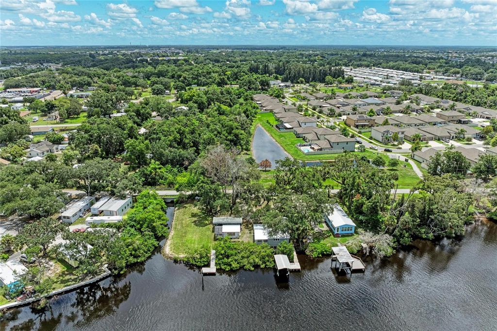 An aerial view shows waterfront homes with private docks and a nearby residential neighborhood — 1609 SAFFOLD PARK DRIVE, RUSKIN, FL