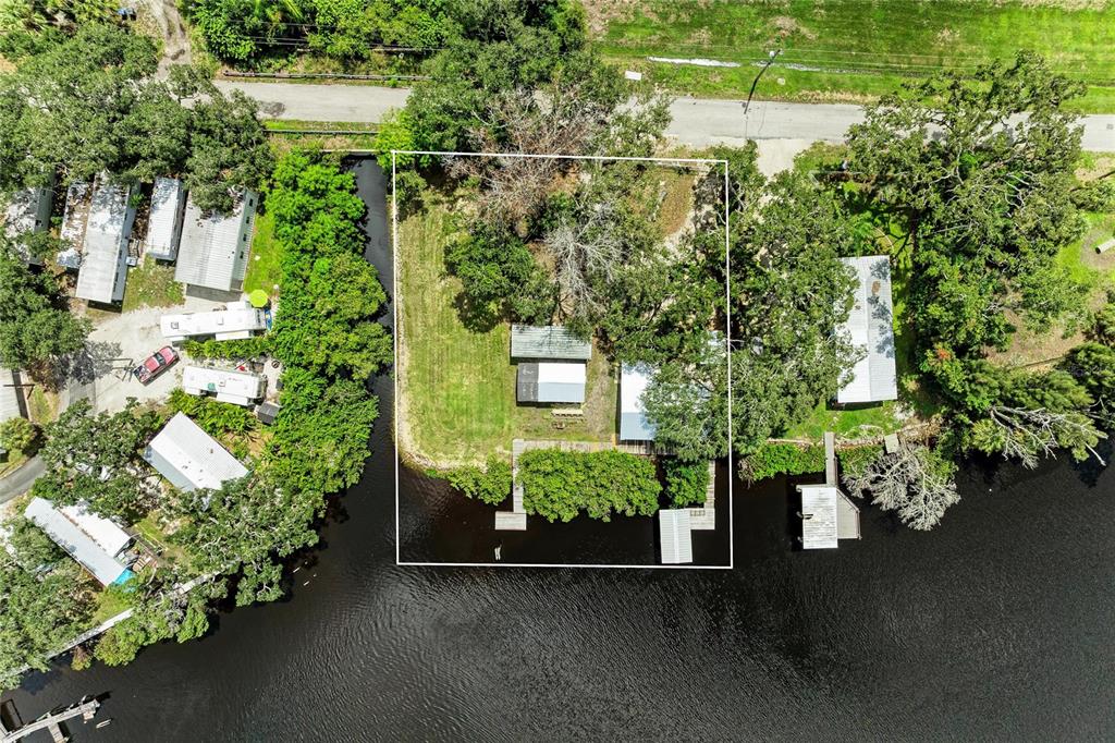 An aerial view shows a waterfront property with a house, shed, and private dock — 1609 SAFFOLD PARK DRIVE, RUSKIN, FL