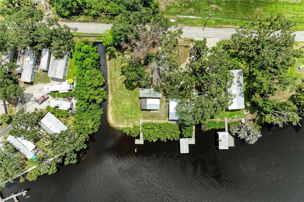 An aerial view shows several mobile homes and docks situated along a dark water canal — 1609 SAFFOLD PARK DRIVE, RUSKIN, FL