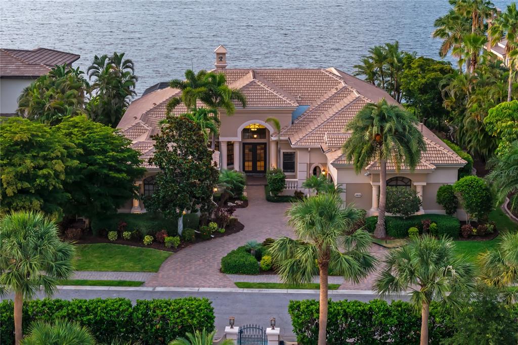 An aerial view of a waterfront house with a paved circular driveway and tile roof — 3803 HAWK ISLAND DRIVE, BRADENTON, FL
