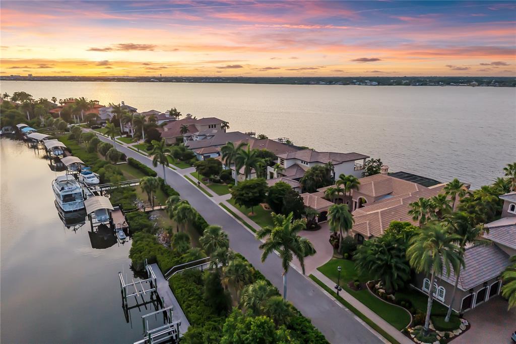 An aerial view shows several waterfront homes with swimming pools and private docks along a canal — 3803 HAWK ISLAND DRIVE, BRADENTON, FL