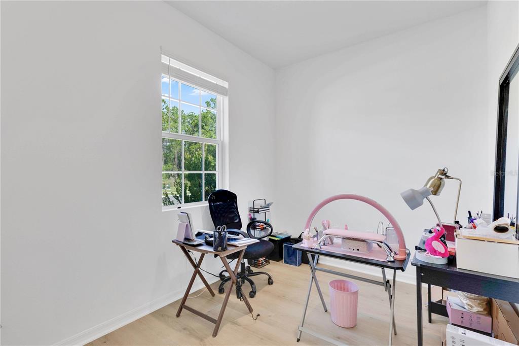 A home office or nail salon room features light wood flooring, white walls, and a window — 1924 COLUMBUS PATH, ST CLOUD, FL
