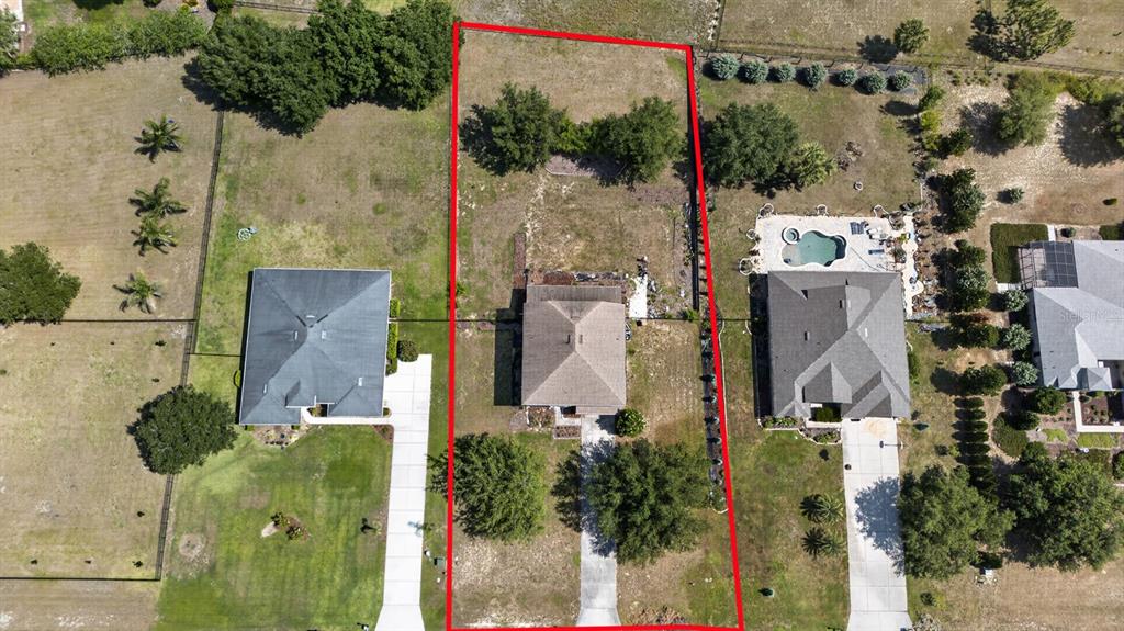 An aerial view shows a single-family home on a rectangular lot outlined in red — 24215 WELDON DRIVE, EUSTIS, FL