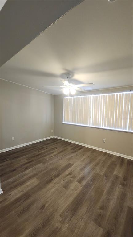 An empty room with wood-look flooring, a ceiling fan, and vertical blinds on the window — 908 WESTMORE AVENUE, BRANDON, FL