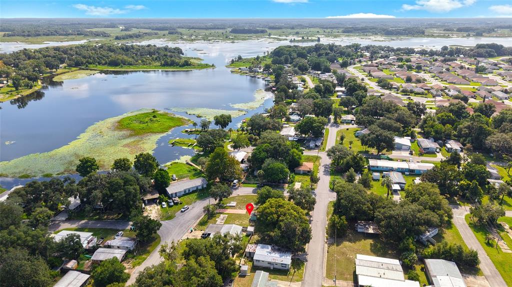 An aerial view shows a residential neighborhood with a lake and a marked vacant lot — 4672 N APACHE TRAIL, HERNANDO, FL
