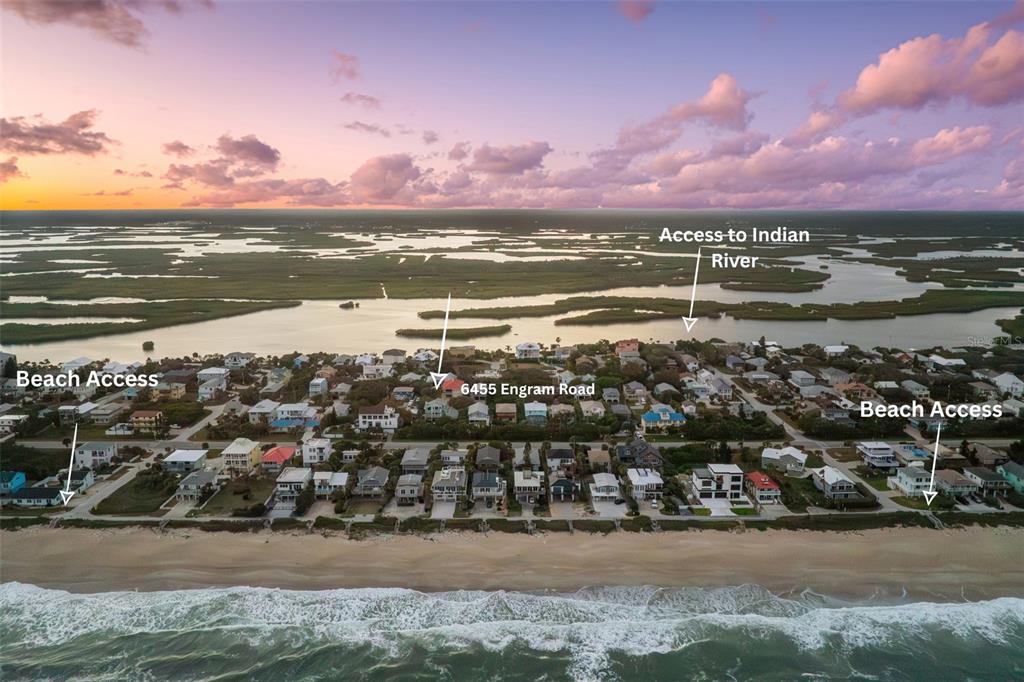 An aerial view shows a coastal neighborhood with houses situated between the ocean and river — 6455 ENGRAM ROAD, NEW SMYRNA BEACH, FL