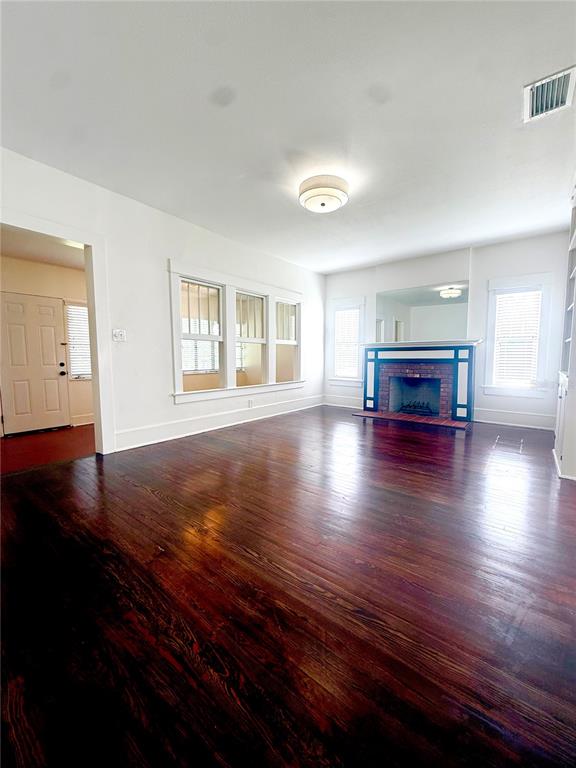 A living room features dark hardwood floors, a brick fireplace, and built-in white shelving — 1903 CURRY FORD ROAD, ORLANDO, FL