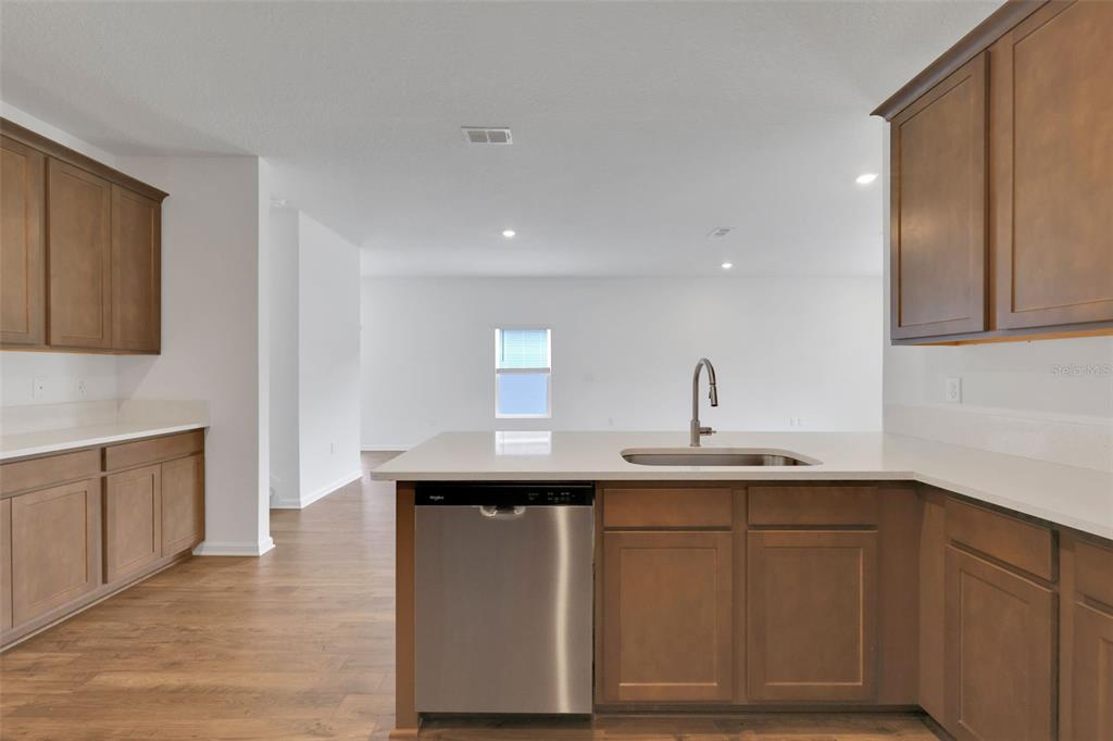 A kitchen features wood cabinets, white countertops, a stainless steel dishwasher, and a sink — 2750 WINDSOR LAKES WAY, GREEN COVE SPRINGS, FL