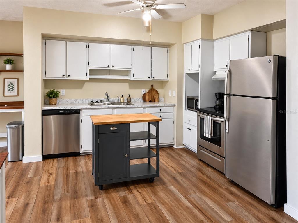 An empty room features blue accent walls, white trim, and wood-look laminate flooring — 665 SE HERON STREET, KEYSTONE HEIGHTS, FL