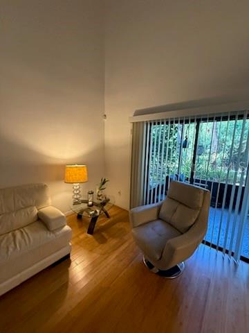 A living room with a white sofa, a swivel chair, and a lamp on a table — 4846 PEBBLE BEACH UNIT 1010B, ORLANDO, FL