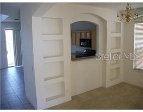 A dining area features built-in wall niches and an arched opening looking into the kitchen — 463 PALOMA DRIVE, DAVENPORT, FL