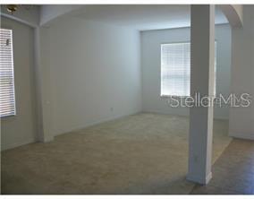 An empty room with beige carpet, white walls, and a large window with blinds — 463 PALOMA DRIVE, DAVENPORT, FL