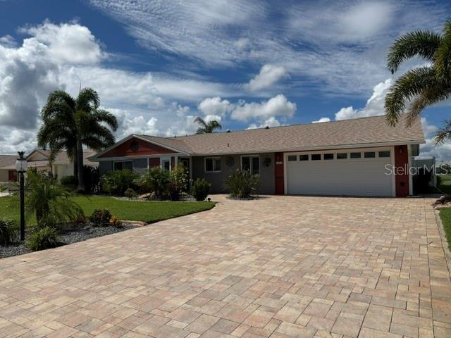 A single-story house with a red-accented exterior, a shingled roof, and a landscaped front yard — 1804 BUNKER HILL DRIVE, SUN CITY CENTER, FL