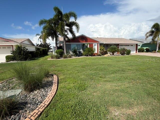A grassy lawn slopes down to a lake with a bird standing near the water — 1804 BUNKER HILL DRIVE, SUN CITY CENTER, FL